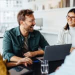 Group of happy business professionals sitting around a table and having a discussion