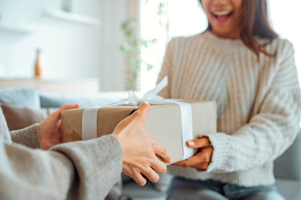 An excited woman getting a surprise gift