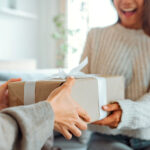 An excited woman getting a surprise gift