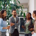 four coworkers happily talking amongst themselves