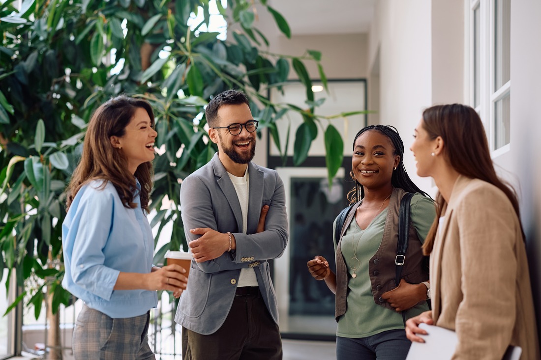 four coworkers happily talking amongst themselves