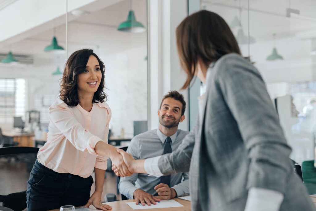 business women shaking hands showing how to negotiate salary