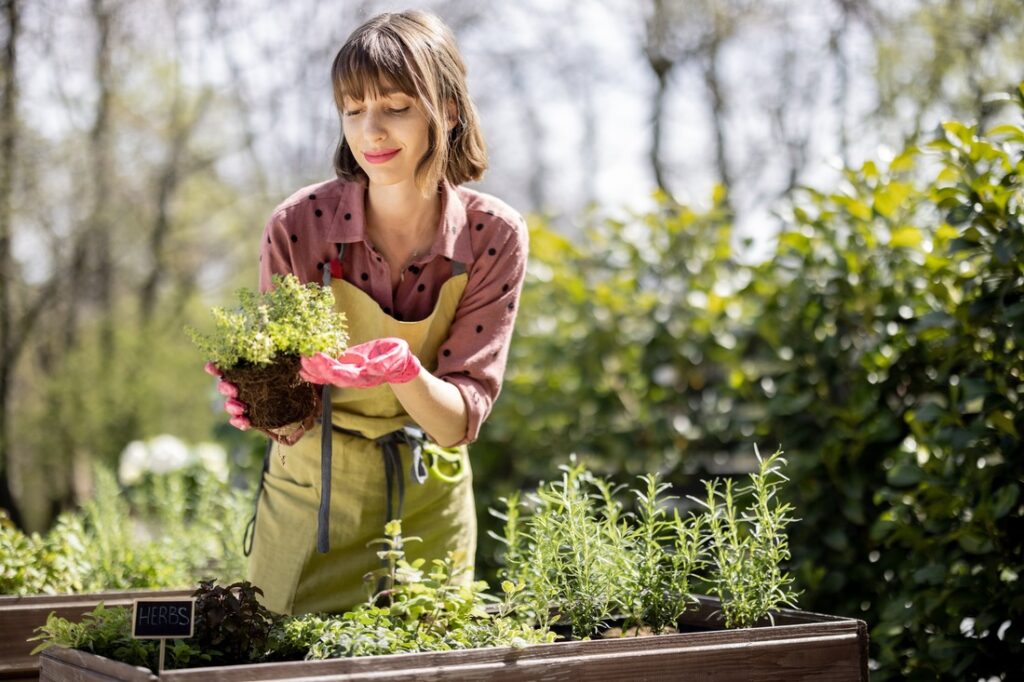 a woman holding a plant in her garden