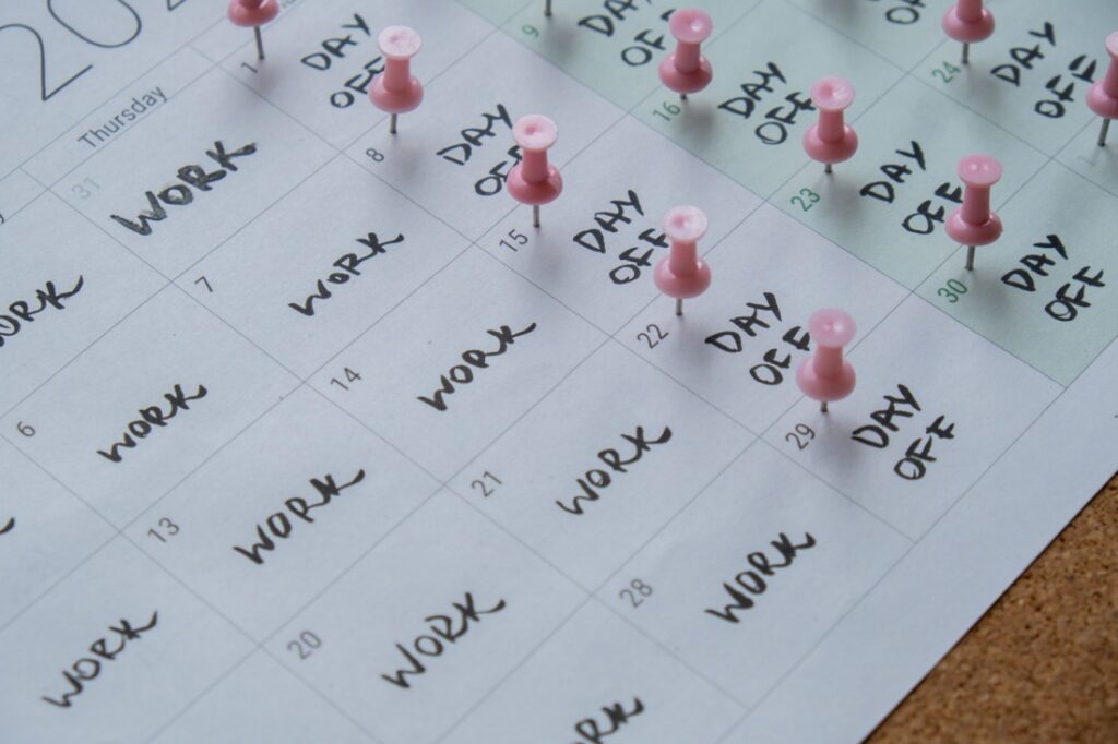 A calendar showing a four day workweek with pushpins on days off.