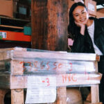 Sahra Nguyen poses next to a pallet in a warehouse.