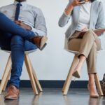 Close up of the different legs of people waiting in chairs for a job interview.