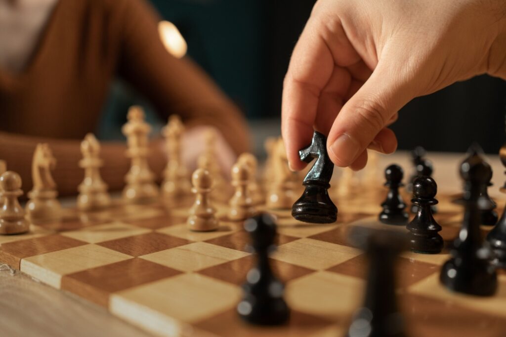 Close up of a hand playing chess.