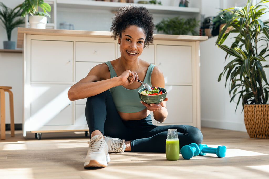 Woman sitting on the ground eating a healthy meal