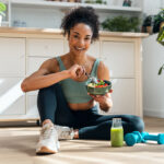 Woman sitting on the ground eating a healthy meal