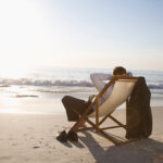 Business man sitting in a chair on the beach