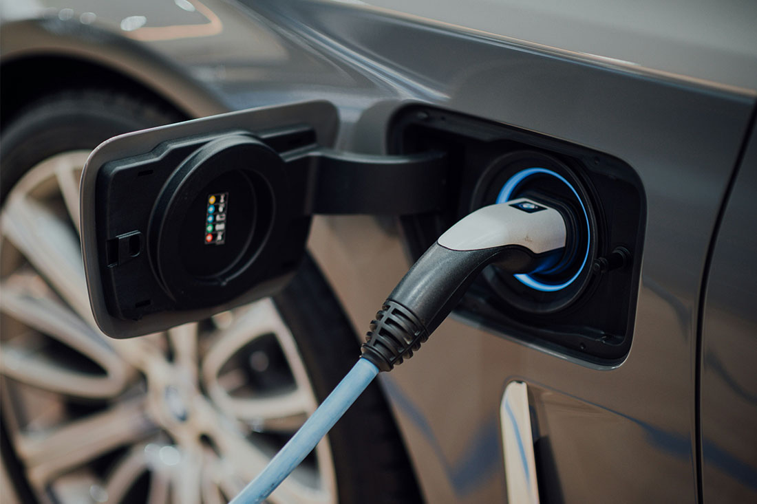 A black and white USB cable plugged into an electric vehicle