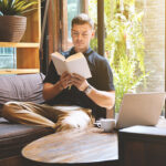 young man reading a book in cafe