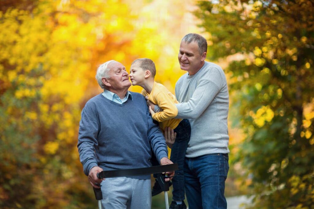 Middle aged man caring for elderly parent and young child as part of the sandwich generation