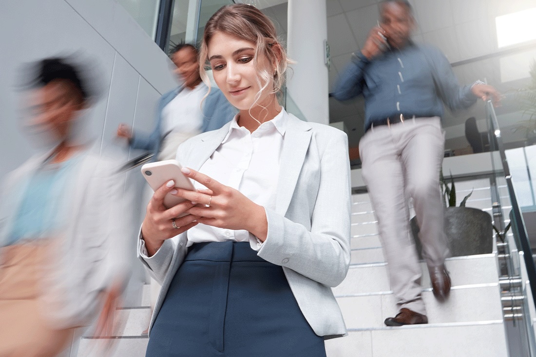 Business woman with smartphone on stairs with motion blur