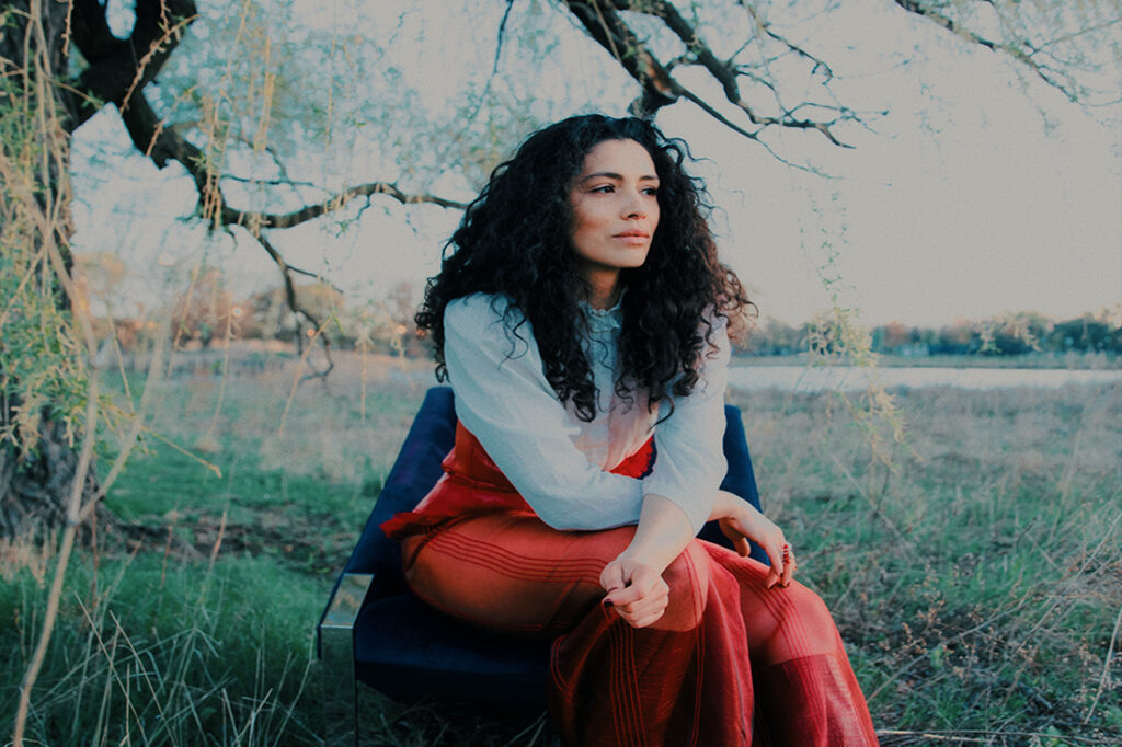 Miranda Rae Mayo sitting beneath a tree