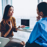 Two women talking to each other in an office