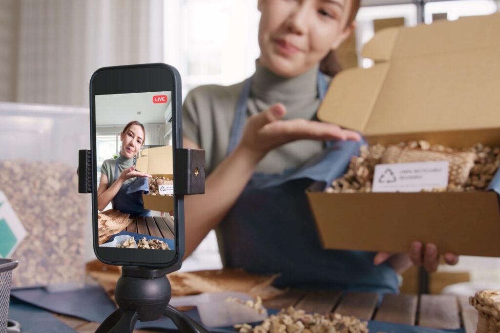 A woman films an unboxing video on her phone