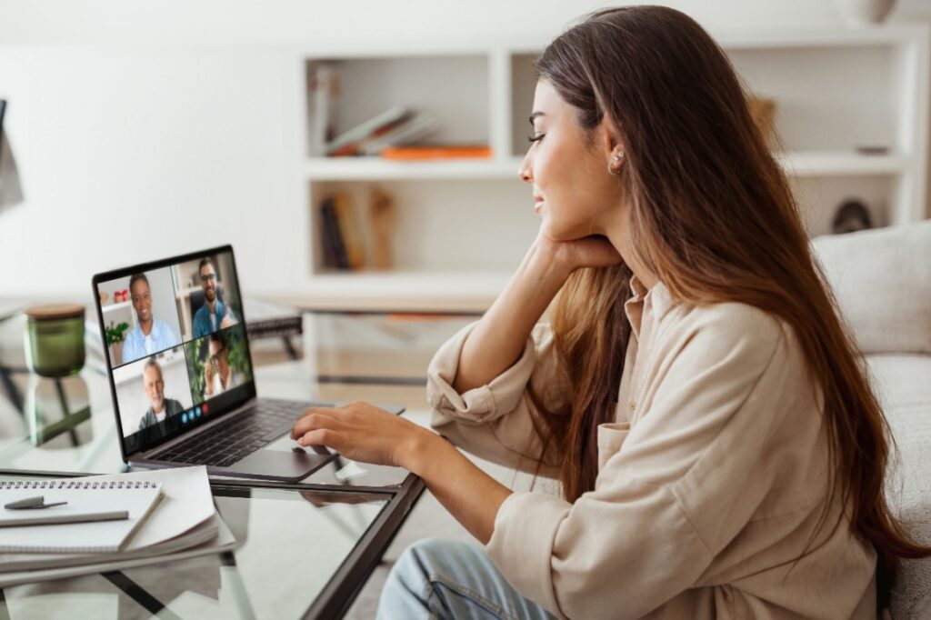 A woman sits at her desk while on a zoom meeting.