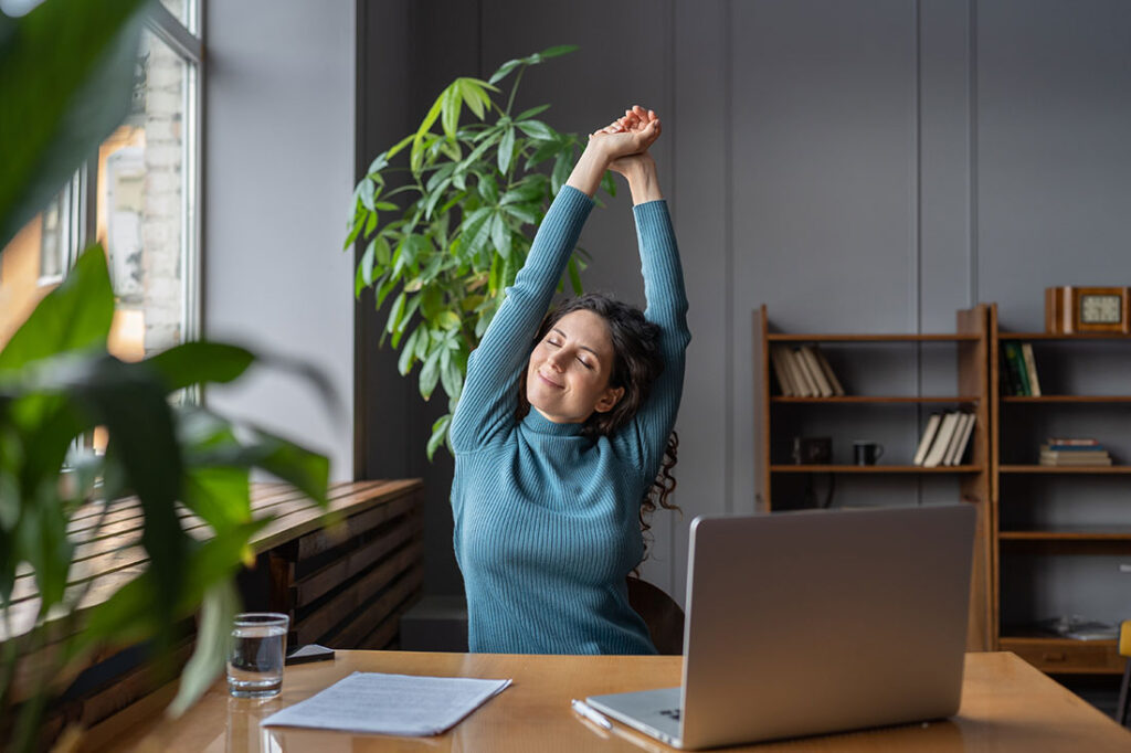 Happy woman stretching at workplace