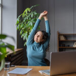 Happy woman stretching at workplace