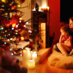 a mother and her two children sitting near a fireplace