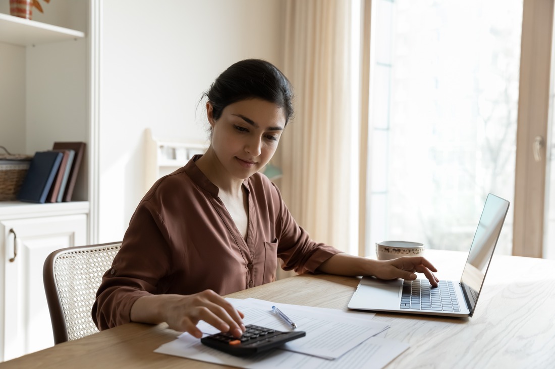 woman sitting at a desk doing paperwork and calculations