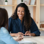 African American woman smiling and talking to colleague