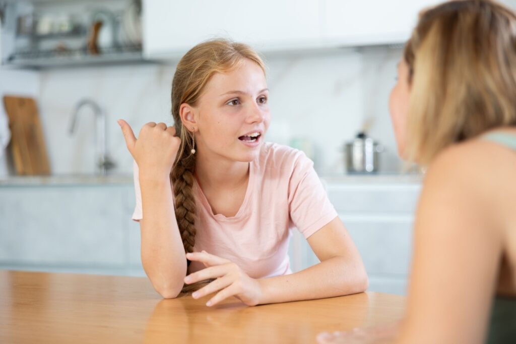 A teenage girl as she talks to her mom.