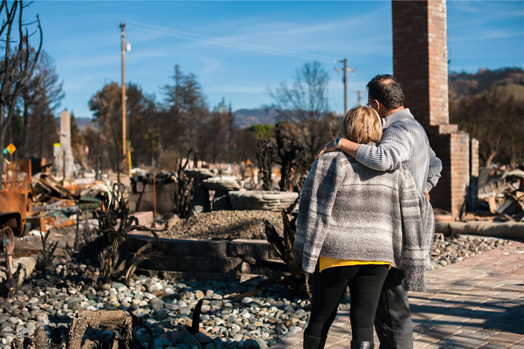 Man and his wife owners, checking burned and ruined of their house and yard after fire