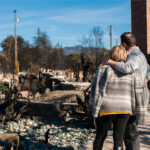 Man and his wife owners, checking burned and ruined of their house and yard after fire