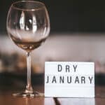 Wine glass with water and sign saying "Dry January"