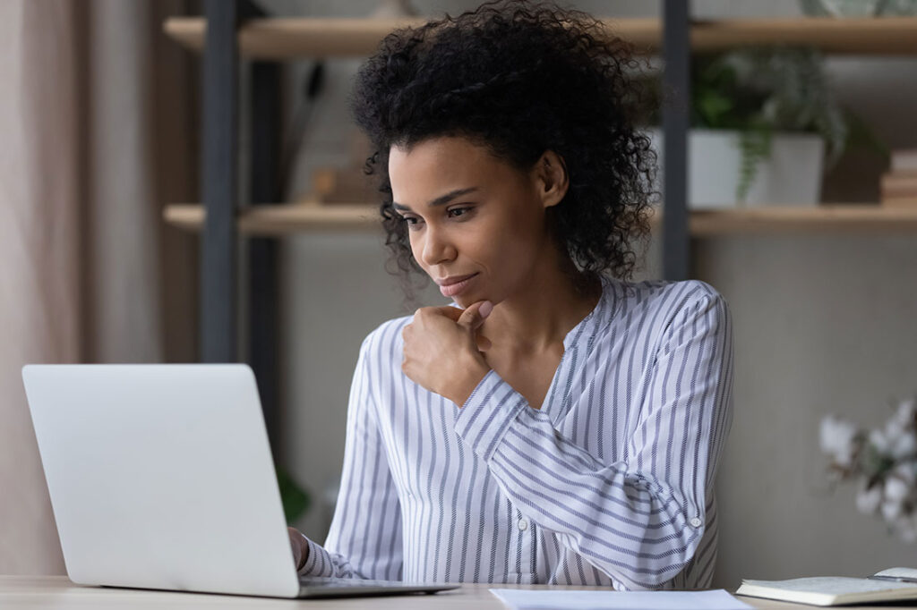 Thoughtful business woman looking at laptop screen