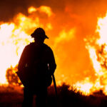 A firefighter watches as the fire burns in California