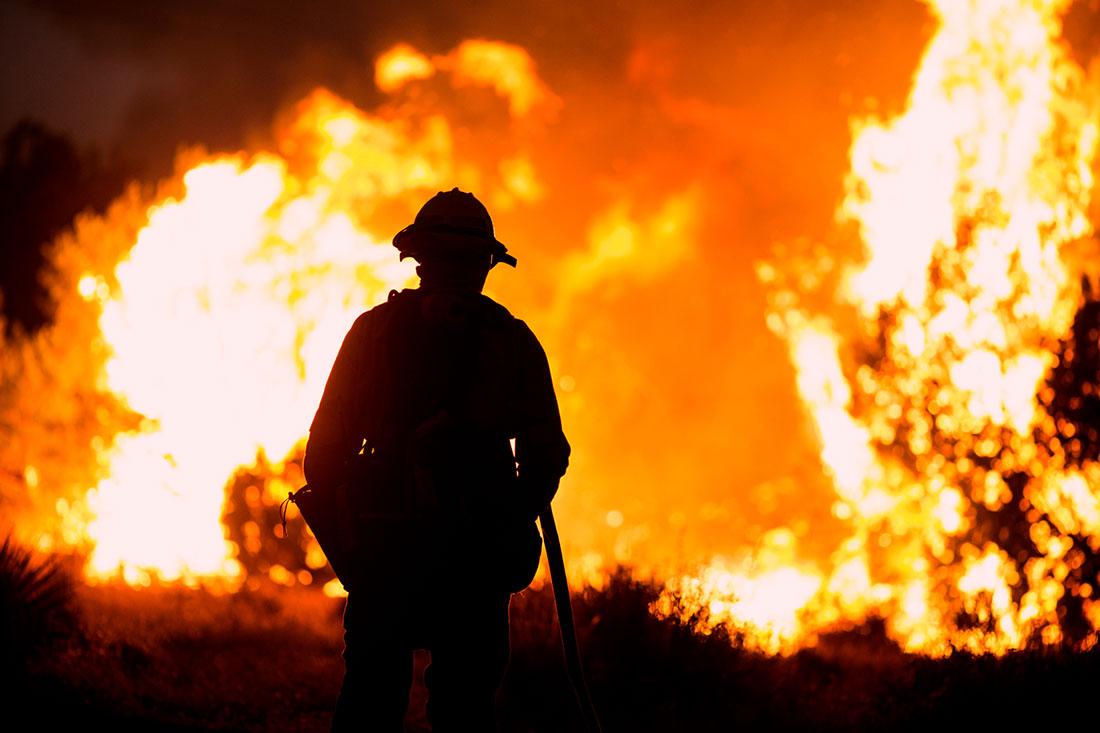 A firefighter watches as the fire burns in California