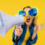 young women shouting into a megaphone trying to stand out