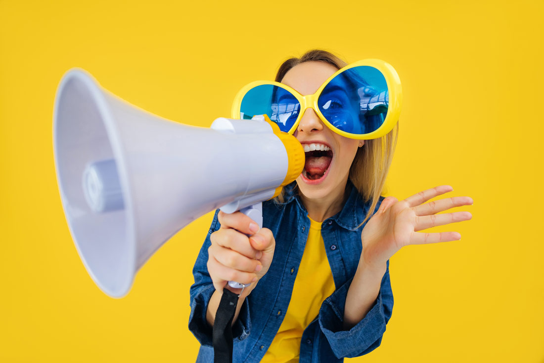 young women shouting into a megaphone trying to stand out