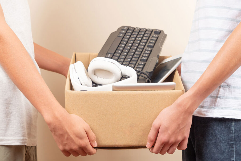 Hands holding a box with used technology