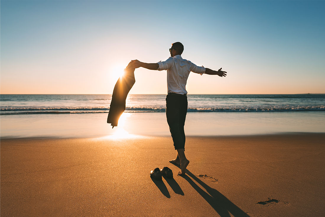 man with open arms enjoying beach landscapes