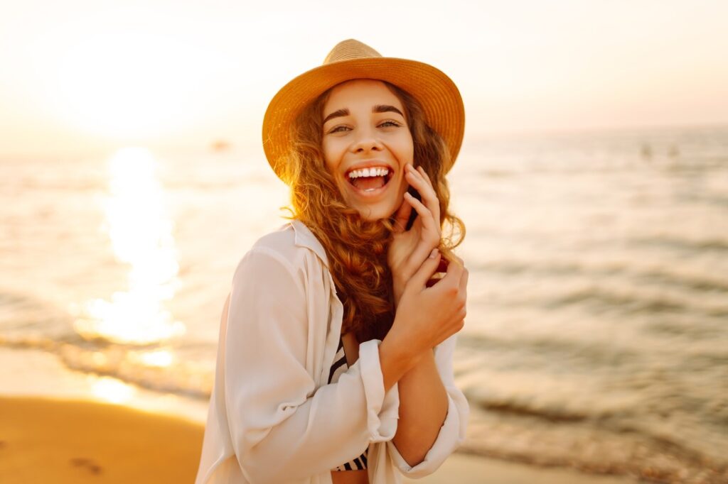 a woman smiling at the beach