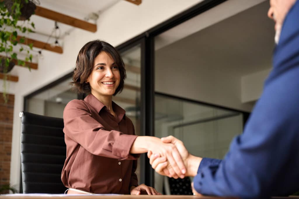 Woman shaking hands at an AI job interview