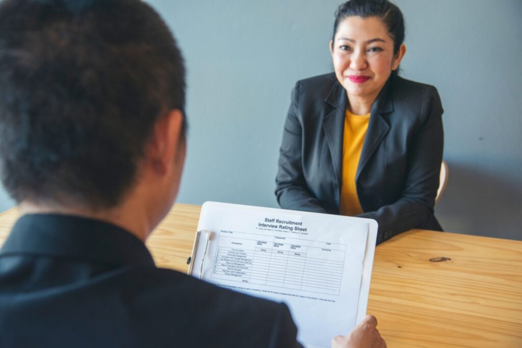 A woman sits across from a man in a job interview.