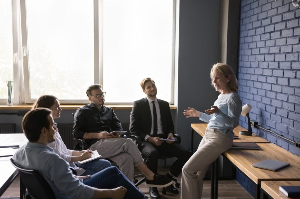 A woman speaks to a group of employees.