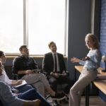 A woman speaks to a group of employees.