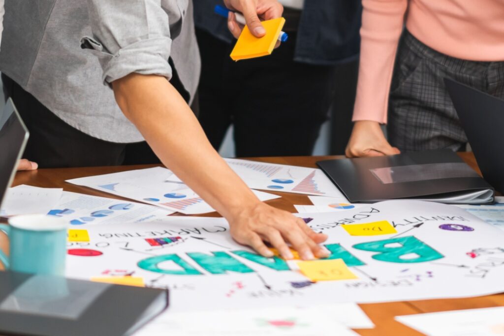 A group of people around documents that say "brand."