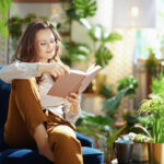 a woman sitting on a chair and reading a book