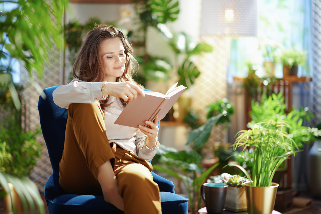 a woman sitting on a chair and reading a book