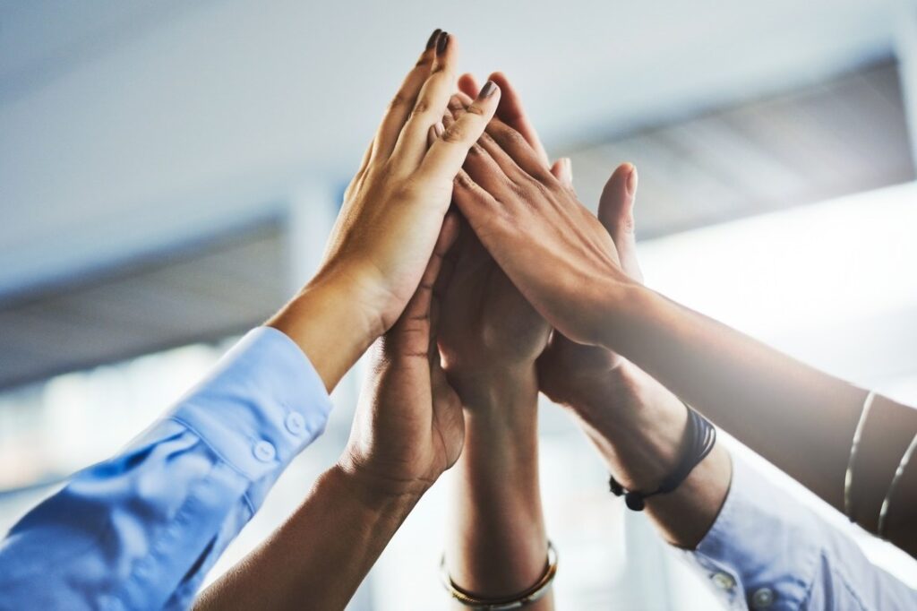 a group of hands in a unified high-five position