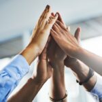 a group of hands in a unified high-five position