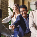 Group of diverse professionals celebrating with a handshake at a corporate event